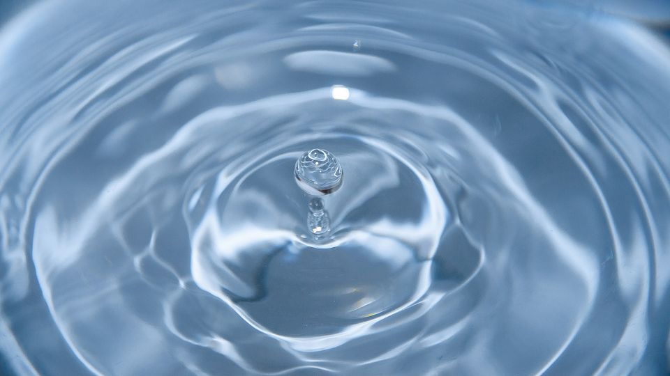 A ripple of water, single drop rising up.