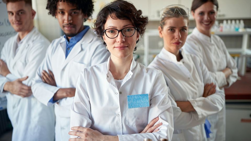 Five male and female cell and gene therapy scientists with their arms crossed.