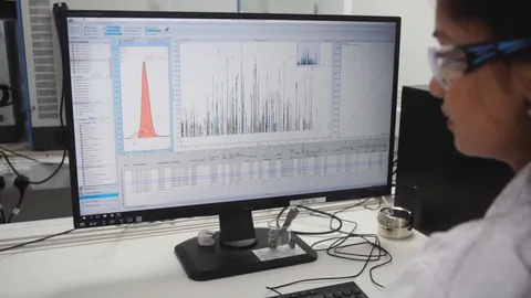 Female scientist working with data using graphs off a computer screen