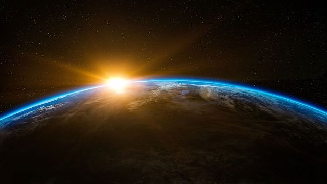 A picture from space looking back at the Earth with the Sun rising from it.