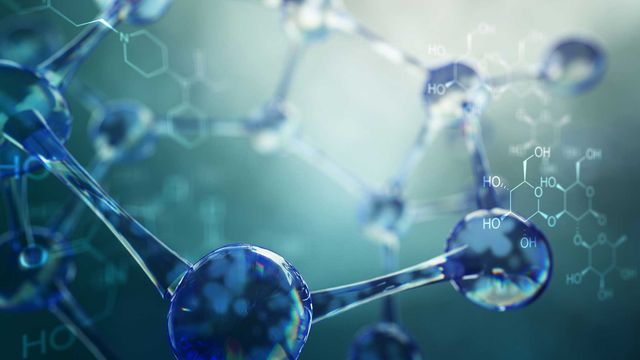 Close up of model of a drug molecule with the chemical structure drawn in white.