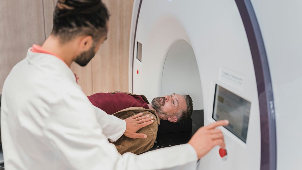 A doctor preparing a patient to undergo a CT scan.