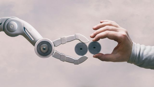 Human and robotic hands collaborating to align metal gears, symbolizing the Fifth Industrial Revolution. 