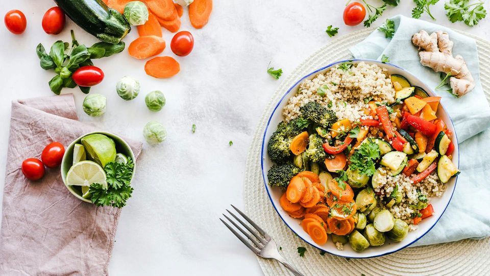 Flat-lay photography of a bowl of grains and vegetables.