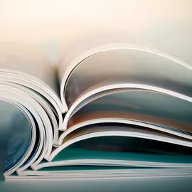 Academic textbooks laid open on a table reflecting academic publishing. 