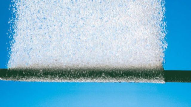 Microbubbles generated by a sparger pipe against a clear blue background. 