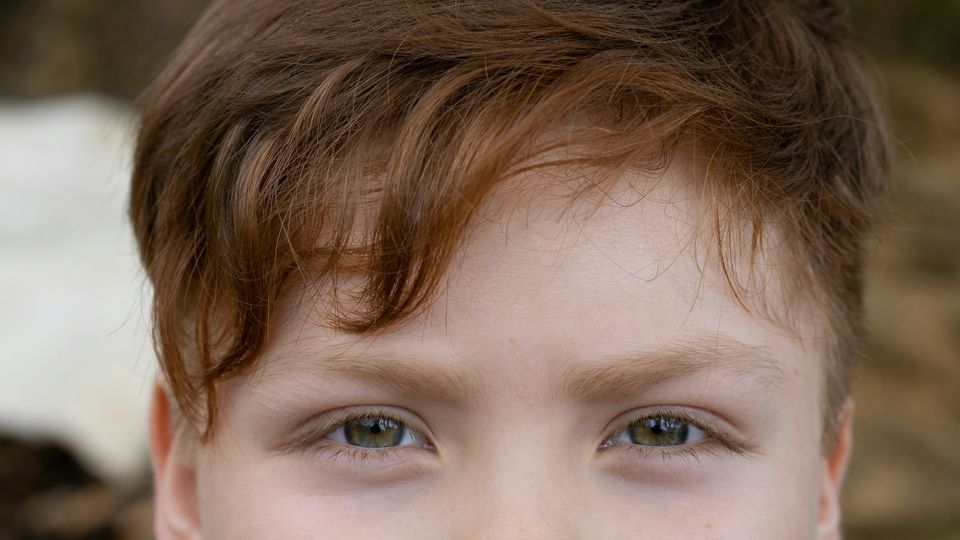 A close-up photo of the top-half of a young boy's face. 