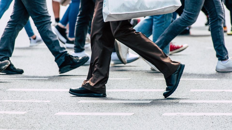 Pedestrians walking on a street, with image showing only lower half of bodies.