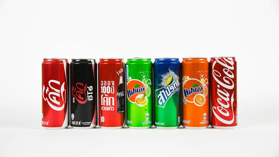 Row of colorful soda cans representing different sugary drinks.