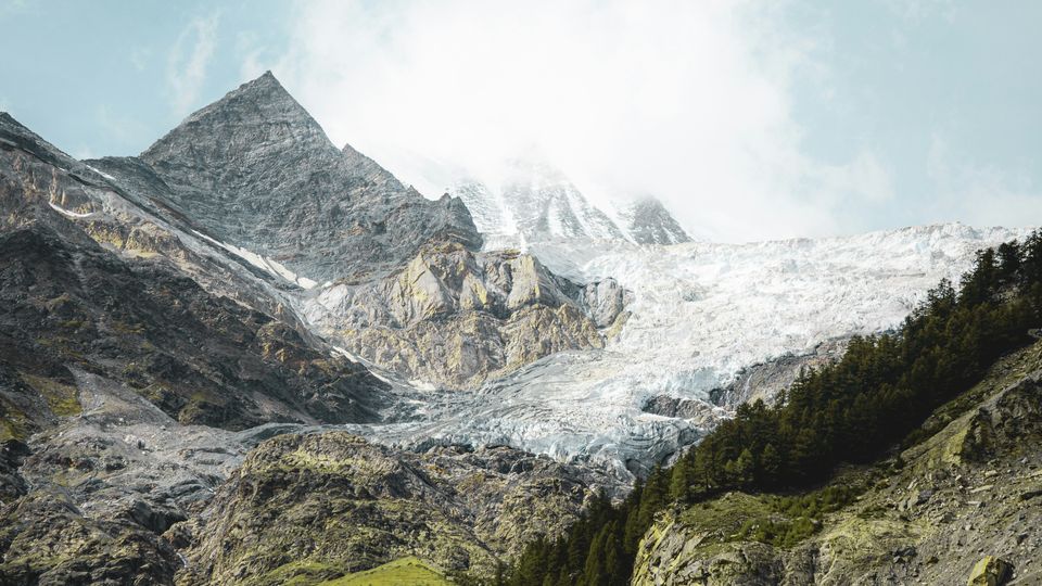 A white glacier sitting in the mountains of Switzerland.