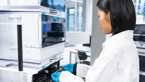 Scientist operating an HPLC system in a lab to overcome metal interference in liquid chromatography.