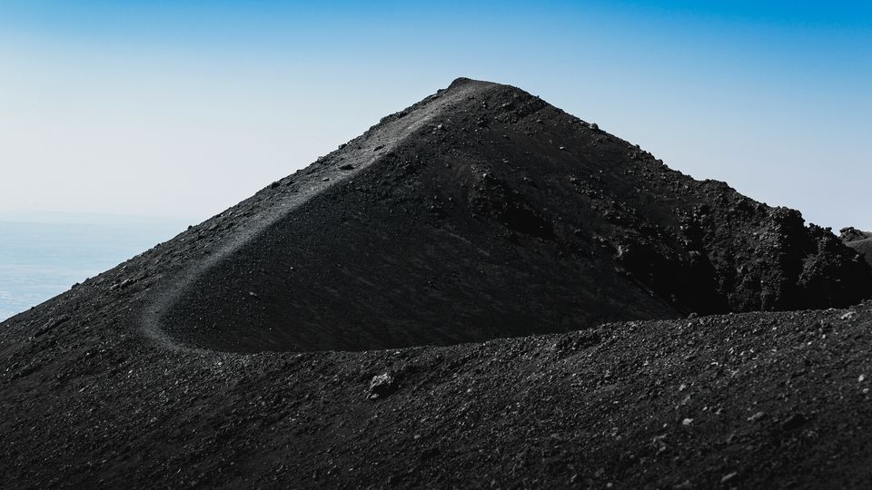 The twisting black slope of a mound of volcanic soil.