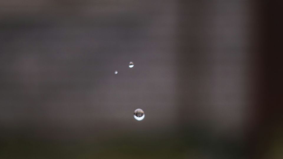 An outdoor tap. Three drops fall from its end.