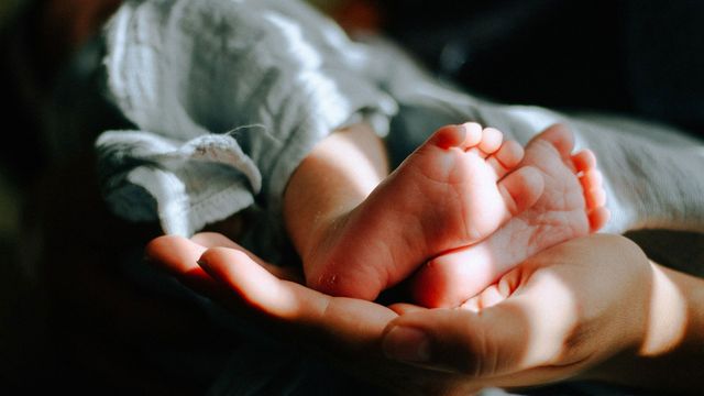 A baby's feet on an adult's hand, symbolizing neonatal diabetes. 
