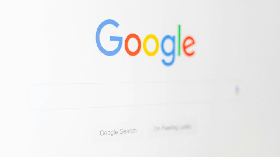 Close-up of the Google homepage with logo and search bar on a computer screen.