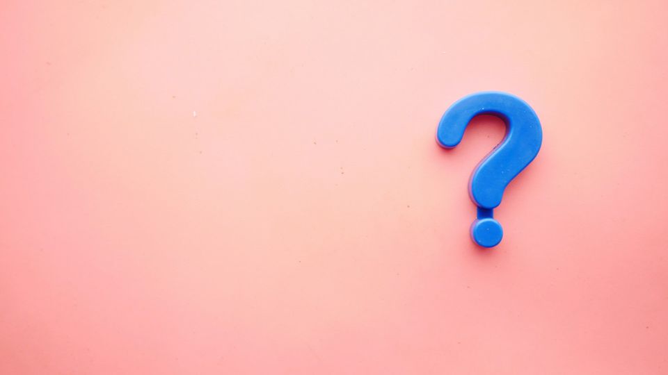 Blue question mark on a pink background symbolizing uncertainty in decision-making.