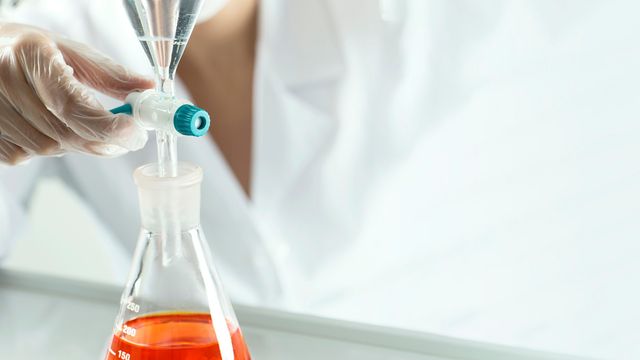 Scientist performing AAV purification using a filtration system to optimize viral vector recovery and purity in bioprocessing. 