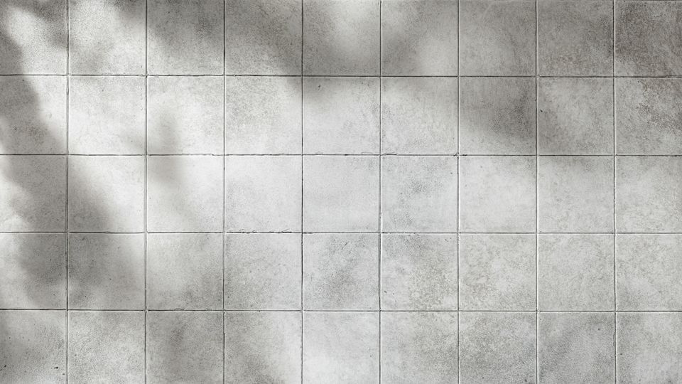 A wall of white and gray ceramic tiles.