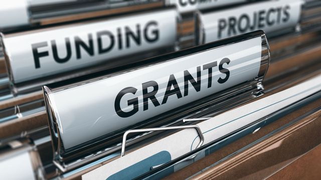 Close up of a filing cabinet with "grants", "funding", and "projects" written on tabs. 