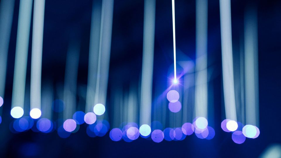 A bright beam of blue-toned light, with more beams out of focus behind it.