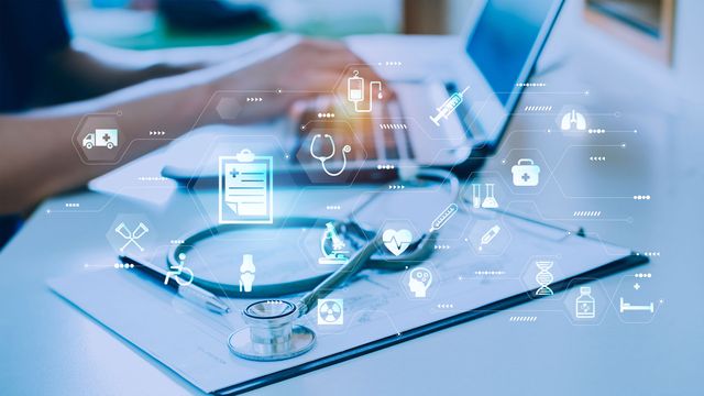 Icons symbolizing health, treatment and diagnosis surround a clinician at a laptop, illustrating the role of AI in medicine. 
