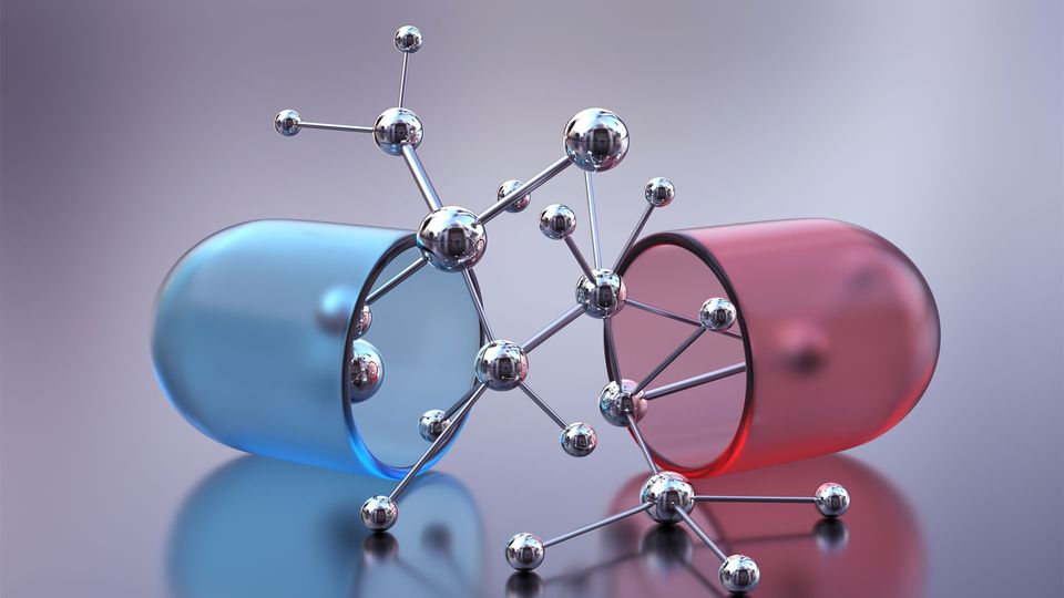 Red and blue drug capsule split in half with silver molecule spilling out.