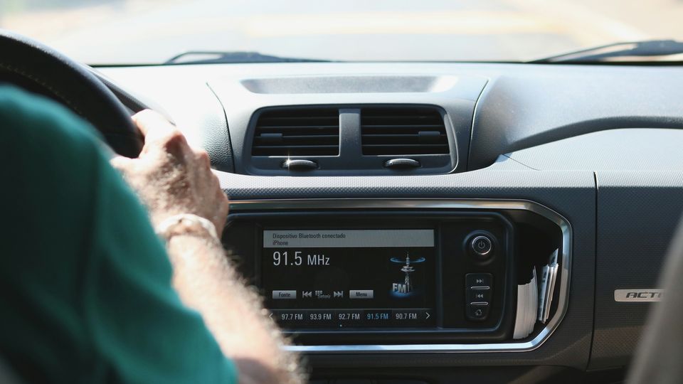A driver listening to the radio in his car.