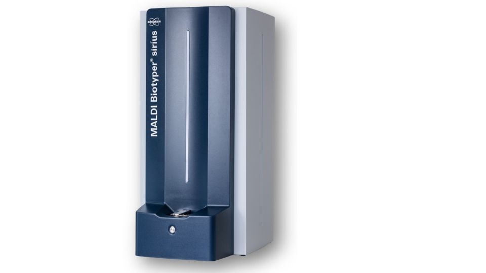 The MALDI Biotyper CA System, a tall, sleek, rectangular mass spectrometry instrument used for microbial identification, with a modern blue and white design and labeled "MALDI Biotyper sirius" on the front.