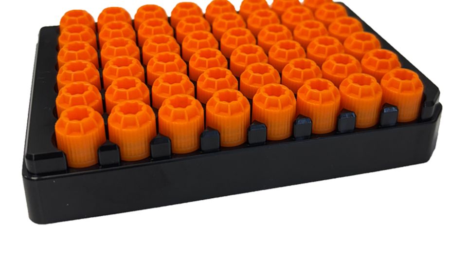 Black rack holding multiple orange screw caps for 24- and 48-format sample tube carriers.