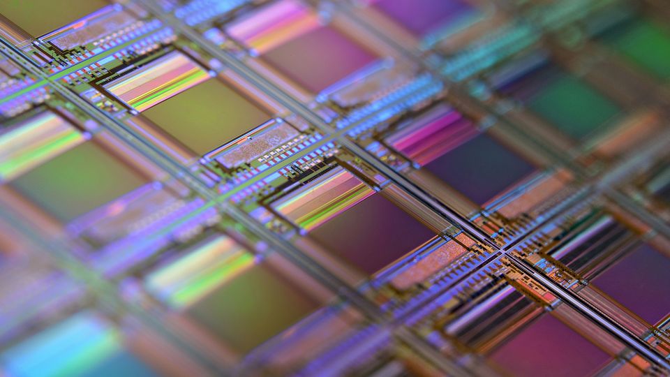 A macro photograph of a patterned silicon wafer, ready for use in electronics. 