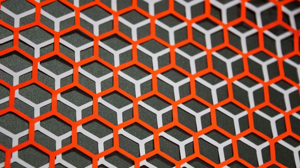 Overlapping orange and white hexagons on a black background.