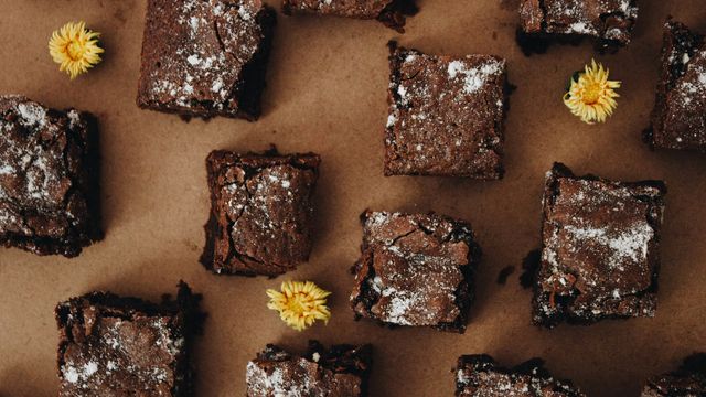 An overhead photo of square brownie slices sat on baking paper. 