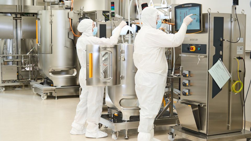Scientists wearing PPE working in ReiThera's bioprocessing facility.