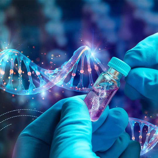 Gloved hands holding a vial with a depiction of DNA strands inside and on the background. 