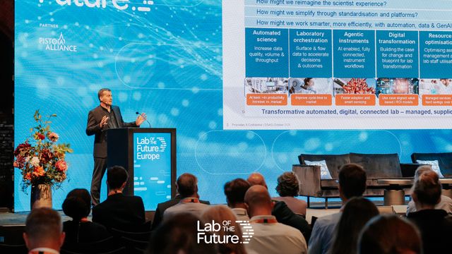 Mark Fish presenting his keynote talk, in front of a large screen. 