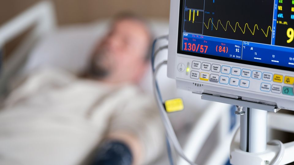 Hospital patient monitored on vital-sign equipment, illustrating links between infection-related hospitalization and increased dementia risk.