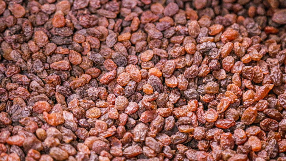 A large collection of brown and black raisins.