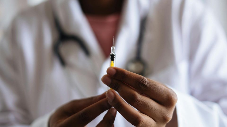 Healthcare worker holding a vaccine syringe, illustrating year-round RSV immunization to prevent severe seasonal surges.