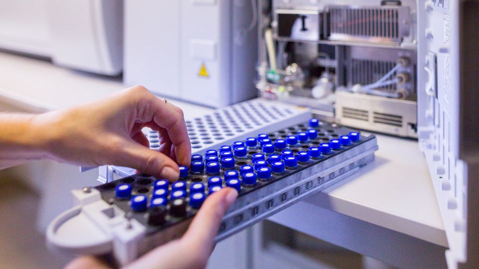 Lab technician loading sample vials for analytical workflows ensuring GLP-1 receptor agonist safety.
