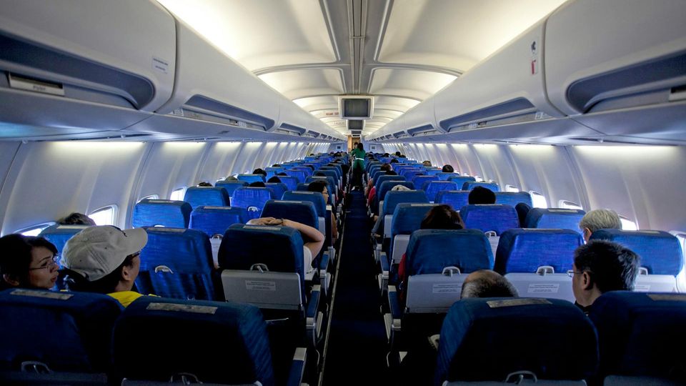Passengers seated in a commercial airplane cabin, relevant to in-flight air quality analysis.
