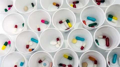Assorted pills in white cups illustrating pharmaceutical methods for drug preparation.