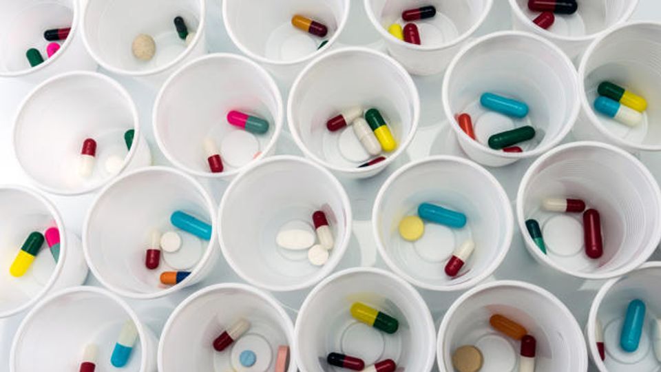 Assorted pills in white cups illustrating pharmaceutical methods for drug preparation.