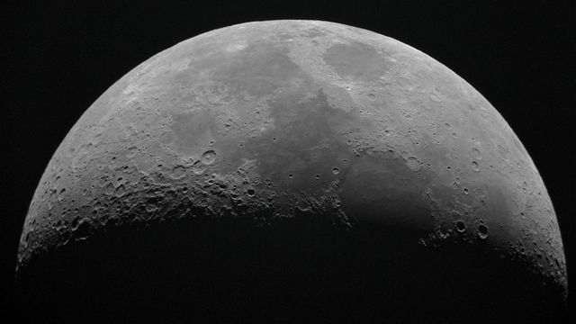 The top surface of the moon with the bottom surface fading to black. 