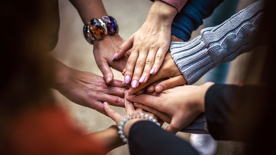 Diverse hands stacked together symbolizing inclusion in drug discovery and FDA trials