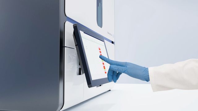 Scientist uses touchscreen on digital PCR system for advanced six-channel dPCR multiplexing. 