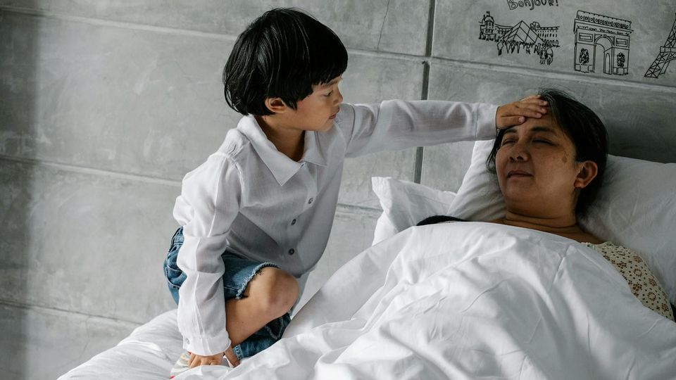Child touching a sick woman in bed, illustrating immune system response to infection.