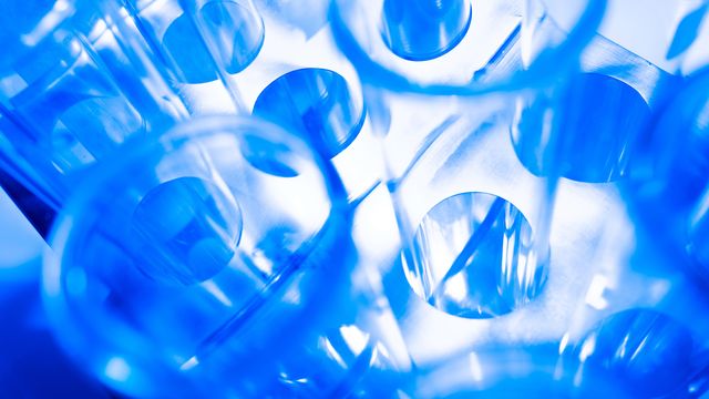Close up image of test tubes in a tripod on a abstract chemical background. 