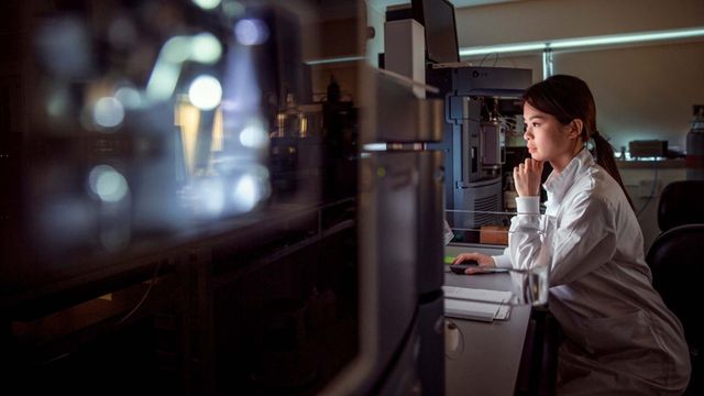 Research scientist analyzing binding kinetics data on a laboratory instrument computer screen. 
