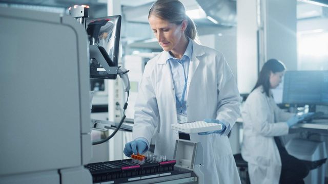 Laboratory scientist loading samples into an ultra-low temperature freezer for biomedical research storage. 