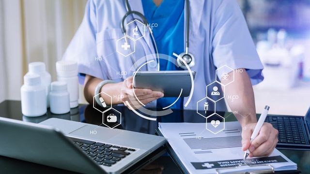 Clinician reviewing clinical research data on a tablet, illustrating digital data management in healthcare. 